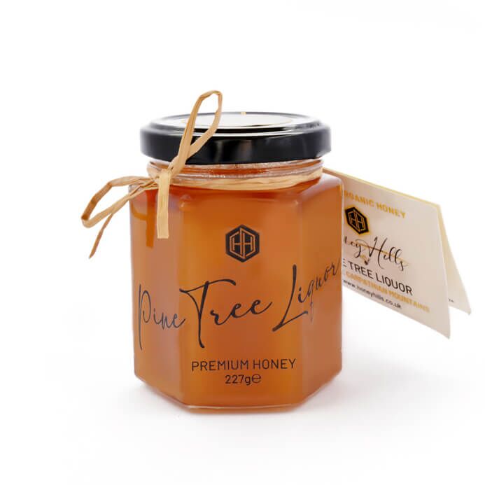 Pine-1 - Honey Hills - Online artisan shop with delicious, rare raw mountain honey varieties Premium Mountain Pine Tree Honey in a charming jar, showcasing rich amber color, perfect for pairing with creamy cheeses and desserts.