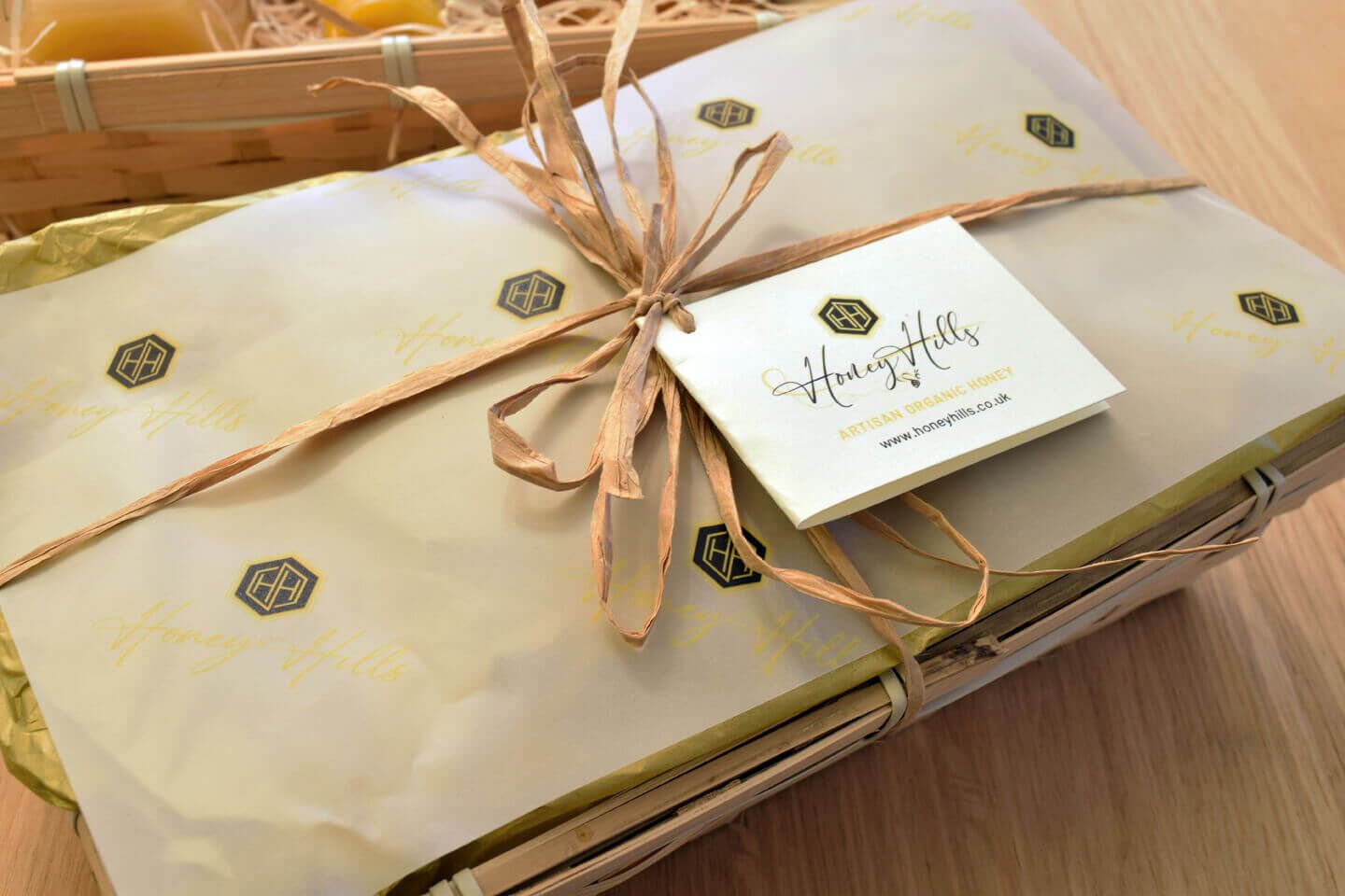 organic-honey-gift-basket-honey-hills.jpg - Honey Hills - Online artisan shop with delicious, rare raw mountain honey varieties Gift basket wrapped in logo-pattern paper with "Honey Hills" label for organic honey.